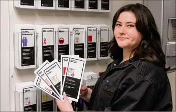  ?? Sue Ogrocki / Associated Press ?? Abby Tow, a sexual health peer educator at the University of Oklahoma, displays some of the sexual health pamphlets available at the health center on campus last week in Norman, Okla. Tow said she wonders if helicopter parenting has played a role in what she calls the “baby-fication of our generation.”