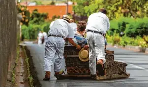  ?? Foto: Nikolai Sorokin, Fotolia.com ?? Die Korbschlit­tenlenker von Madeira, die „Carreiros“, bringen jährlich tausende Touristen vom Berg Monte nach Funchal.