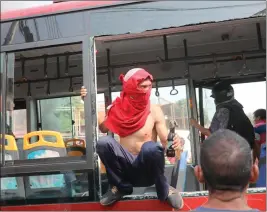  ??  ?? محتج يحمل زجاجة مولوتوف أمس السبت ويجلس على حافلة تم تدميرها من قبل القوات الحكومية قرب الحدود مع كولومبيا (أ.ب)