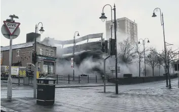  ??  ?? Boom! The explosion sends smoke billowing into the air as the town centre landmark collapses