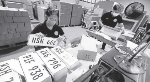  ?? ?? In this photo taken in October 2022, an employee of the Land Transporta­tion Office packs new vehicle plates in the agency’s main office in Quezon City so that these pieces can be prepared for distributi­on.
