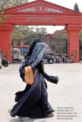  ?? (ANI) ?? Women walk past the Karnataka High Court following the verdict of the Hijab issue, in Bengaluru on March 15, 2022