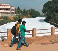  ?? AFP ?? Residents walk past a polluted river in Bangalore, India, which is experienci­ng a severe shortage of clean water.