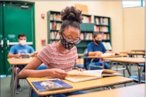  ?? Contribute­d photo / Spring ISD ?? Students practice social distancing and wear protective masks while learning in the classroom.