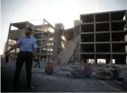  ?? AP PHOTO ?? DAYTIME STRIKE: A Palestinia­n policeman guards a destroyed building after an Israeli airstrike in Gaza City yesterday.