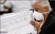  ?? (AP/Ben Gray) ?? An election worker sorts and stacks ballots Tuesday in Lithonia, Ga., as the state begins an official machine recount of its roughly 5 million votes cast in the presidenti­al race.