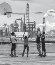  ?? Karen Kasmauski ?? Teens play basketball at a public park near Motiva. Many are concerned that air pollution is at the root of cancer among Port Arthur’s residents.