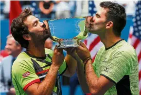  ??  ?? Sealed with a kiss: Men’s doubles winners Jean-Julien Rojer (left) and Horia Tecau kissing their trophy after defeating Feliciano Lopez-Marc Lopez 6-4, 6-3 on Friday.