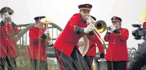  ?? PHOTO: SUPPLIED ?? Flying fanfare . . . St Kilda Brass members (from left) Toby Brown, Kimberley Johnston, Susie Grigg, Hamish Tildesley (obscured, drum), and Nadia Kevill perform for Air New Zealand’s new safety video beside the Balclutha Bridge on Sunday. Peter McHendry (out of shot) plays the tuba.