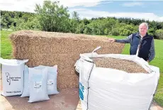  ??  ?? Jim Mackintosh beside bags of the easily-handled pellets