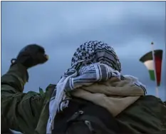  ?? ?? A man wearing a keffiyeh raises his fist and a Palestinia­n flag during a protest against the war in Gaza on the Auraria campus on Thursday.