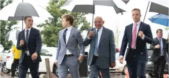  ??  ?? Elzie Higginbott­om (third from left) arrives for the wedding of Tara Flocco and Patrick Daley.