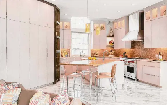  ?? Jeanette Bergen ?? More cabinets and extra lighting, as well as a custom-made table that intersects with the island, make the Potylchans­kys’ kitchen more stylish and functional.