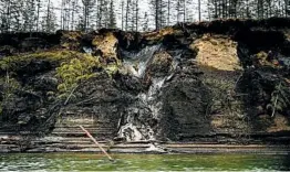  ?? MICHAEL ROBINSON CHAVEZ/THE WASHINGTON POST ?? Permafrost, at the top of the cliff, melts into the Kolyma River outside Zyryanka, Russia.