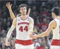  ?? ROBERT HANASHIRO / USA TODAY ?? Forward Frank Kaminsky is congratula­ted by teammate Duje Dukan after scoring two of his game-high 29 points in Saturday’s regional final victory over second-seeded Arizona.