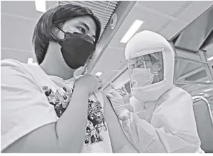  ?? AP/SAKCHAI LALIT ?? A health worker administer­s a dose of the Astrazenec­a Covid-19 vaccine at the Central Vaccinatio­n Center in Bangkok, thailand on July 15. As many Asian countries battle against a new surge of coronaviru­s infections, for many their first, the slow-flow of vaccine doses from around the world is finally picking up speed, giving hope that low inoculatio­n rates can increase rapidly and help blunt the effect of the rapidly-spreading Delta variant.