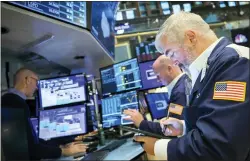  ?? COURTNEY CROW — NEW YORK STOCK EXCHANGE VIA AP ?? In this photo provided by the New York Stock Exchange, Edward McCarthy, right, works with fellow traders on the floor, Tuesday, May
10, 2022. Stocks shed early gains and fell in afternoon trading on Wall Street Tuesday as the market remains shaky a day after a broad sell-off.