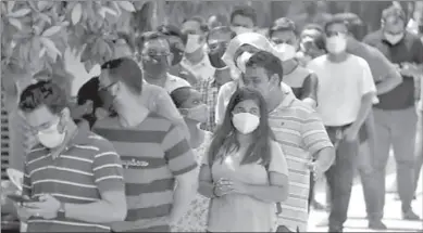  ??  ?? NEW DELHI
People wearing protective face masks wait to receive a dose of COVISHIELD, a coronaviru­s disease (COVID-19) vaccine manufactur­ed by Serum Institute of India, outside a vaccinatio­n centre in Ahmedabad, India. -AFP