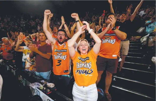  ?? Picture: STEWART McLEAN ?? GOING WILD: Glenn Jones and Sheree Gall celebrate the Taipans’ win at the finish of the Cairns Convention Centre game.