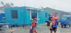  ?? PHILIPPINE COAST GUARD ?? MEMBERS of the Philippine Red Cross response team in Batangas assist residents in a flooded village in Batangas City on Sept. 8, while Coast Guard officers help in the evacuation of communitie­s in various towns in Cavite.