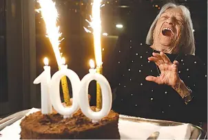  ?? The Associated Press ?? Agnes Keleti, former Olympic gold medal winning gymnast, reacts to fireworks going off on her birthday cake Monday in Budapest, Hungary.