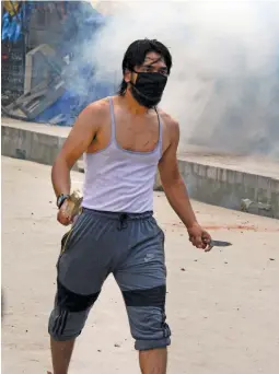  ?? — PTI ?? A protester holds a knife and a stone during a clash with the security forces in Srinagar on Friday following a protest over the arrest of Dukhtaran-i-Millat chairperso­n Aasiya Andrabi under Public Saftey Act.