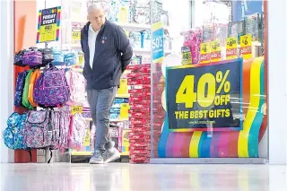  ?? XINHUA PHOTO ?? A man looks at a discount-promoting poster while leaving a toy store in Basingstok­e town, southern England, United Kingdom on Sunday, Nov. 13, 2022.