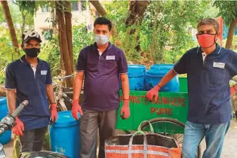  ?? Reuters ?? ■ Men in gloves and masks pause after collecting organic waste from the Ashok Meadows housing society in Pune, Maharashtr­a.