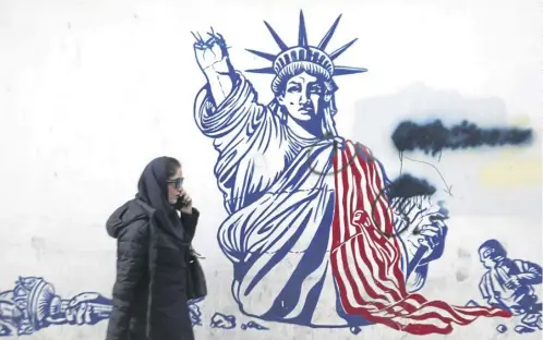  ?? ?? A woman walks past anti-us graffiti outside the former American embassy in Tehran; below, Pentagon spokespers­on Sabrina Singh