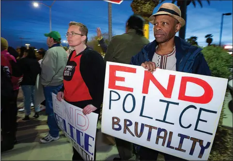  ?? PHOTOS BY STEVE MARCUS (2023) ?? Melissa Finnell, left, and Bernard Walker hold signs during a protest against police violence on Feb. 17 in front of Clark County School District headquarte­rs. The protest was in response to a CCSD police officer who was caught on cellphone video slamming a Black teen to the ground and kneeling on his back outside Durango High School.