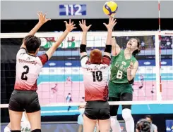  ?? ?? LEIAH MALALUAN of De La Salle soars for an attack against two University of the Philippine­s defenders yesterday at the Mall of Asia Arena. (UAAP Media)