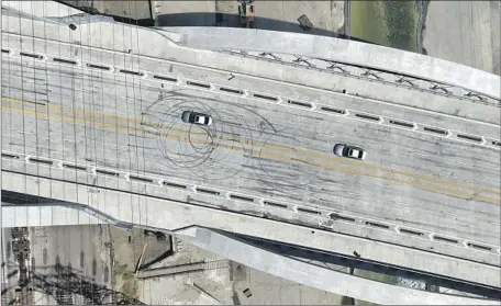  ?? Myung J. Chun Los Angeles Times ?? THE 6TH Street Viaduct already shows the marks from a street takeover, and graffiti has been painted over on the recently opened span. The LAPD has added patrols, and transit officials are considerin­g higher fencing and a median that the original plans didn’t call for.