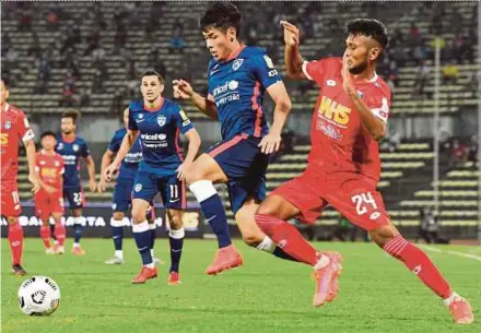  ?? BERNAMA PIC ?? Johor Darul Ta’zim’s Mohd Afiq Faizal (second from right) vies with Sabah FC’s Mohd Syukri Baharun (right) during their Super League match on Tuesday.