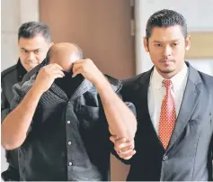  ??  ?? The senior officer from the Melaka Tengah District Police Headquarte­rs being escorted out of the courtroom after his release. — Bernama photo