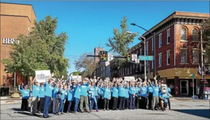  ?? DONNA ROVINS — DIGITAL FIRST MEDIA ?? A group of community members and business leaders took to the streets of Pottstown Thursday to launch a new economic developmen­t initiative led by PAID Inc. Shown here, the group waves as part of a video being filmed. The tagline for the campaign is “I...