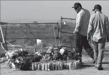  ?? MEL MELCON/LOS ANGELES TIMES ?? People visit a memorial near the crash site on Cecil Avenue in Delano for Santos Hilario Garcia and Marcelina Garcia Profecto. The two immigrants in the country illegally, died while fleeing ICE.