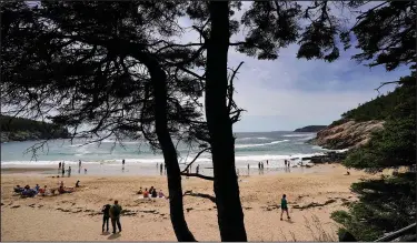  ?? (AP/Robert F. Bukaty) ?? Beachgoers enjoy Sand Beach on June 11 in Acadia National Park near Bar Harbor, Maine. The park will not have lifeguards on duty this summer due to worker and housing shortages.