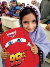  ??  ?? August 31, 2016: A young girl smiles when she receives a schoolbag and stationery donated by the CFPD at the China- Pakistan Government Primary School in Faqeer Colony, Gwadar.