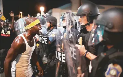  ??  ?? Manifestan­te encara policiais no protesto contra absolvição de um policial branco que matou um negro