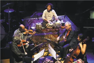  ?? Photos by Scott Strazzante / The Chronicle ?? Percussion­ist Zakir Hussain plays with the Kronos Quartet during the SFJazz gala.