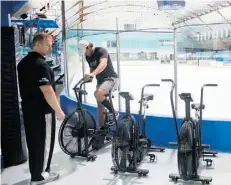  ??  ?? Matt Nichol, left, works with a player following an on-ice training session. Players are now working on conditioni­ng before heading off to training camp.