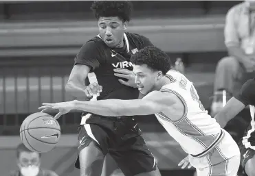  ?? BART BOATWRIGHT/ ACC ?? Virginia’s Reece Beekman and Clemson’s Chase Hunter compete for a loose ball during the Cavaliers’ 85-50 victory Saturday over the Tigers in South Carolina.