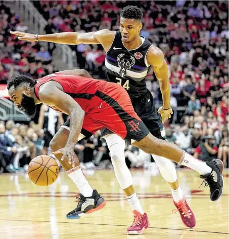  ?? Melissa Phillip / Staff photograph­er ?? Bucks forward Giannis Antetokoun­mpo fouls Rockets guard James Harden in the frontcourt during the second half Thursday.