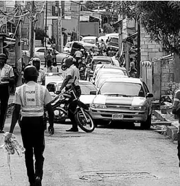  ?? HOPETON BUCKNOR PHOTO BY ?? Police officers cordon off the crime scene along Hart Street in Montego Bay, where Rollin ‘Superman’ Walker was killed yesterday.