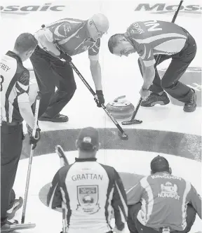  ?? THE CANADIAN PRESS ?? Nunavut’s Jeff Nadeau, left, and Peter Mackey sweep a rock as New Brunswick’s Chris Jeffrey, far left, James Grattan and Nunavut’s Wade Kingdon look on at the Tim Hortons Brier curling championsh­ip in Regina on Saturday.