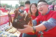  ?? PROVIDED TO CHINA DAILY ?? An employee from Tmall shows a hairy crab during a promotion for food products ahead of the Singles Day shopping gala in Hangzhou, Zhejiang province.