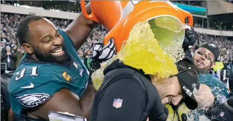  ?? The Associated Press ?? Philadelph­ia Eagles head coach Nick Sirianni (centre) is doused by defensive tackle Fletcher Cox and teammates during the second half of the NFC Championsh­ip. The Philadelph­ia Eagles, favourites, will play the Kansas City Chiefs on Sunday.