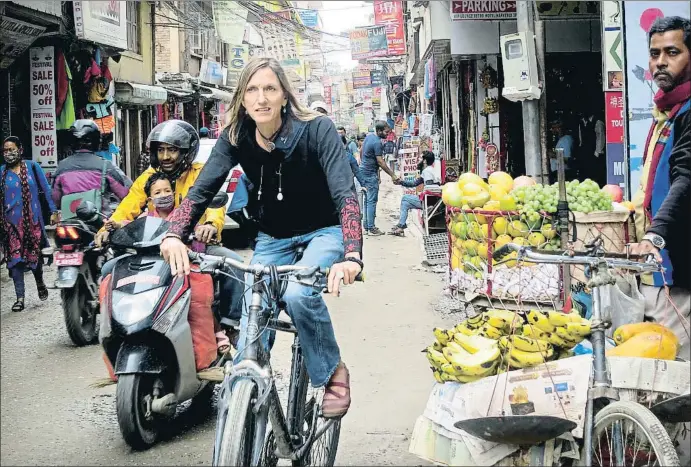  ?? ROSA M. BOSCH. ?? Billi Bierling se desplaza en bicicleta por la capital nepalí; en la foto, en el bullicioso barrio de Thamel, donde realiza buena parte de las entrevista­s a los montañeros