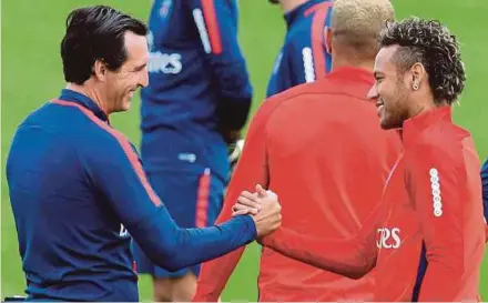  ?? AFP PIC ?? Neymar (right) shakes hands with his new coach Unai Emery of Paris Saint-Germain during training on Friday.