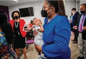  ?? Bill O’Leary/Washington Post ?? Megan Aldridge carries her 3-month old son, Mac, as Biden administra­tion members tour Mamatoto Village’s maternal-care facility in Washington, D.C.